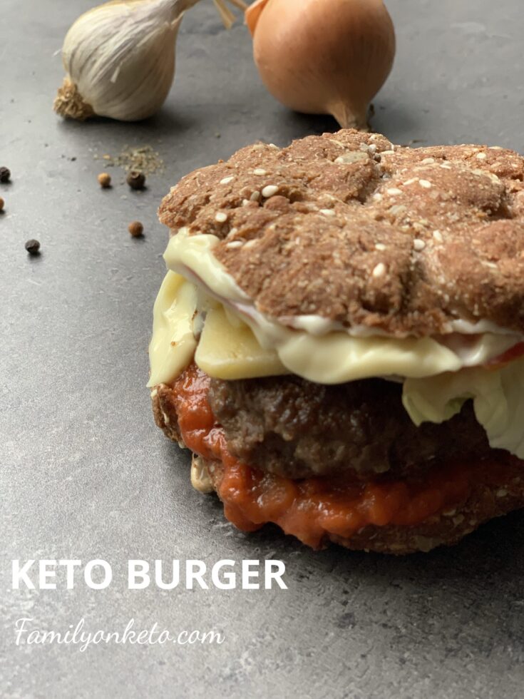 Picture of a keto burger in a keto bun with mayonnaise and keto tomato sauce